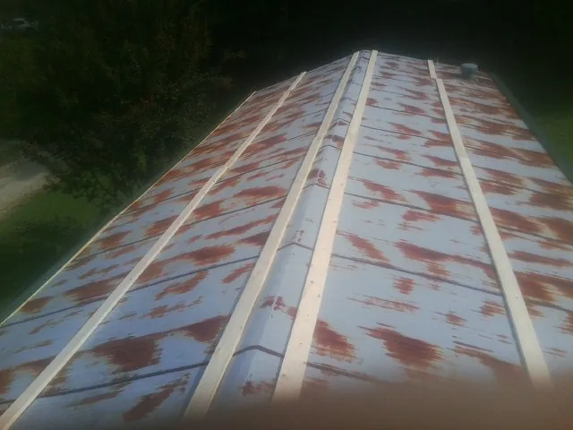 Rusted metal roof panels with new wood purlins before replacement — Storm Damage Roof Repair in Nesconset by Roofing Brothers
