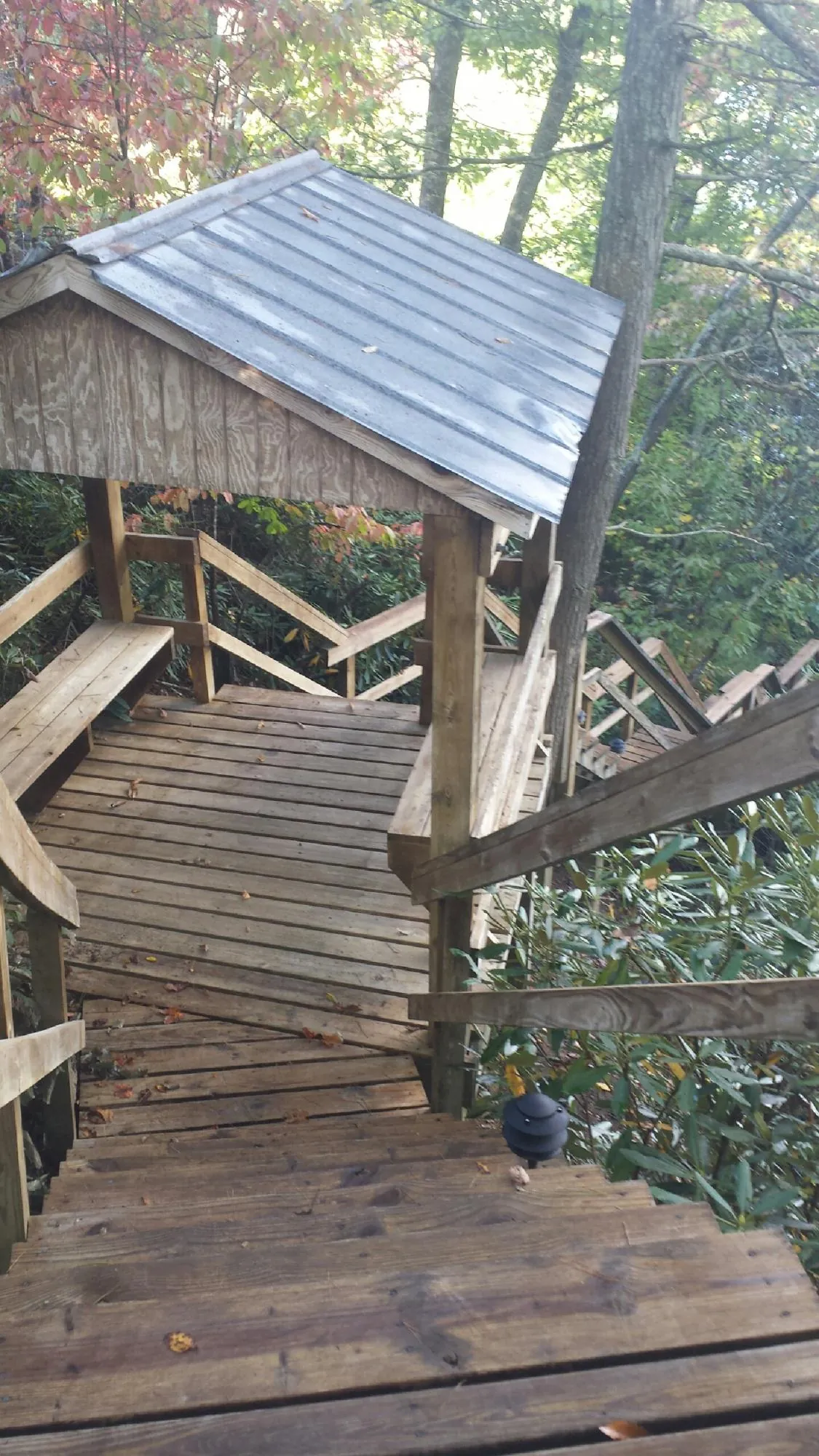 Metal roofed shelter over wooden steps on a wooded walkway — Skylight Repair & Installation work by our crew in Nesconset