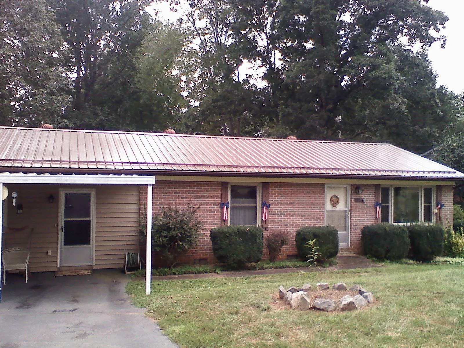 Bronze metal roof and carport on a brick ranch home — Roof Repair work by our crew in Nesconset